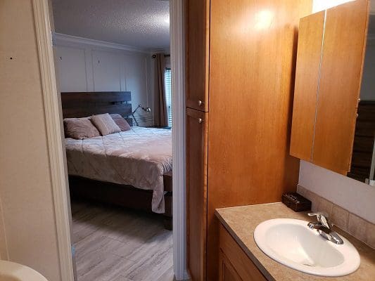 A bathroom with a sink and a bed.