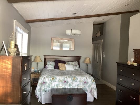 A small bedroom with a bed and dresser.