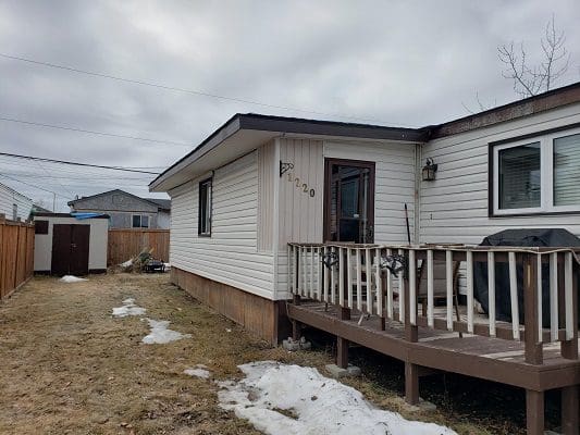 A small house with a deck and a small yard.