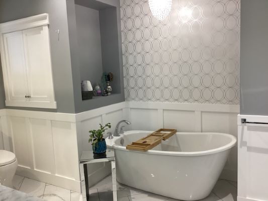 A white and gray bathroom with a tub and sink.