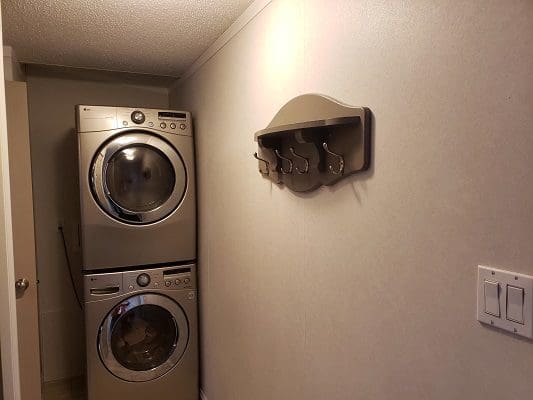 A laundry room with two washers and dryers.