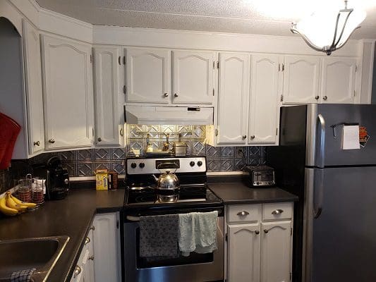 A kitchen with stainless steel appliances and white cabinets.