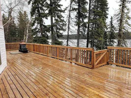 A wooden deck with a view of a lake.