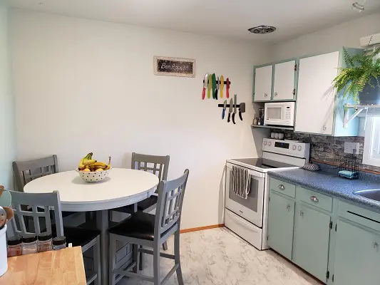 A small kitchen with a table and chairs.