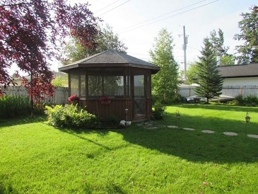 A backyard with a gazebo in the middle of it.