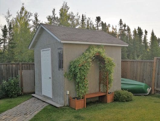 A backyard with a small shed and a boat.