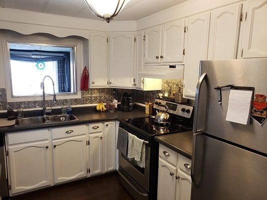 A kitchen with stainless steel appliances and white cabinets.