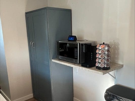 A small kitchen with a microwave and coffee maker.