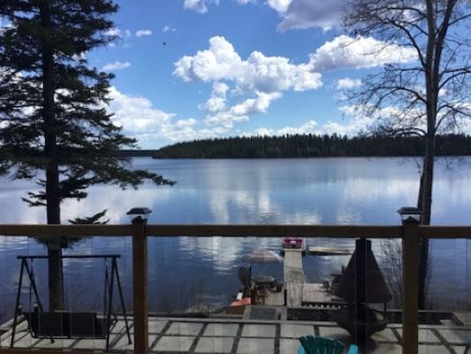 A view of a lake from the deck of a house.