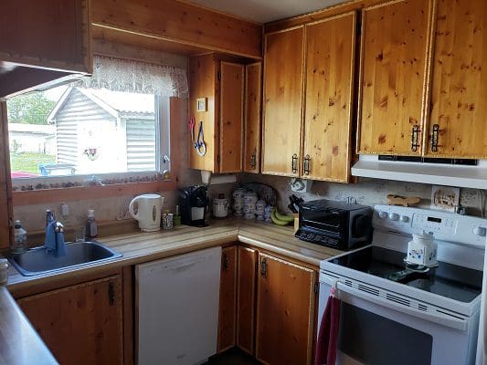 A kitchen with wooden cabinets and a stove.