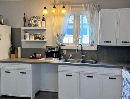 A kitchen with white cabinets and a sink.