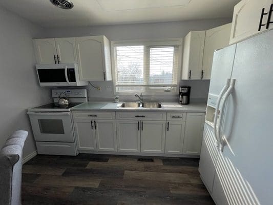 A kitchen with white cabinets and a stove.