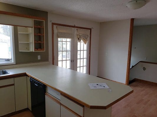 An empty kitchen with a stove and refrigerator.