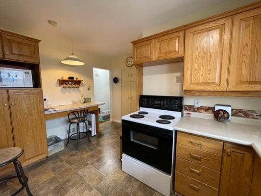 A kitchen with wood cabinets and a stove.