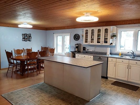 A kitchen with wood floors and a dining table.