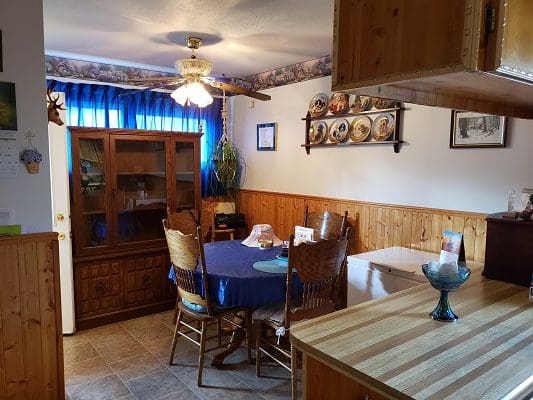 A kitchen with wood paneling and a table and chairs.
