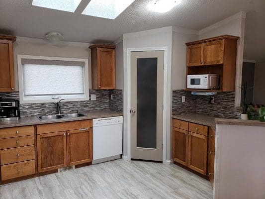 A kitchen with wood cabinets and a skylight.