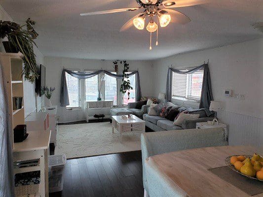 A living room with hardwood floors and a ceiling fan.