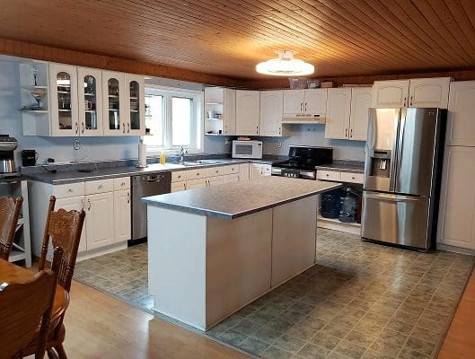 A kitchen with white cabinets and stainless steel appliances.