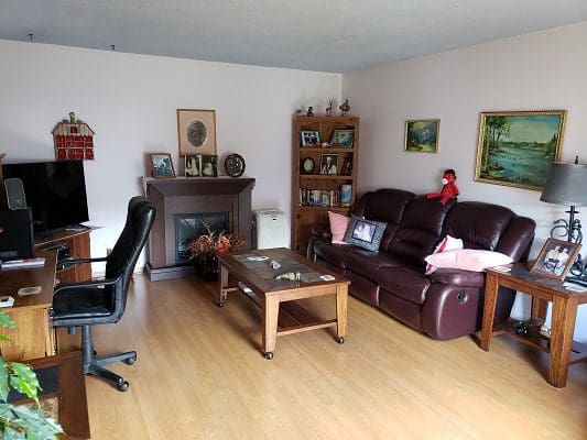 A living room with brown leather furniture and a fireplace.