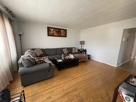 A living room with hardwood floors and a couch.