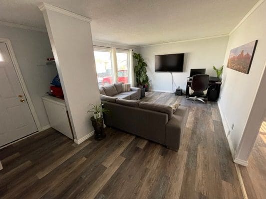 A living room with hardwood floors and a tv.