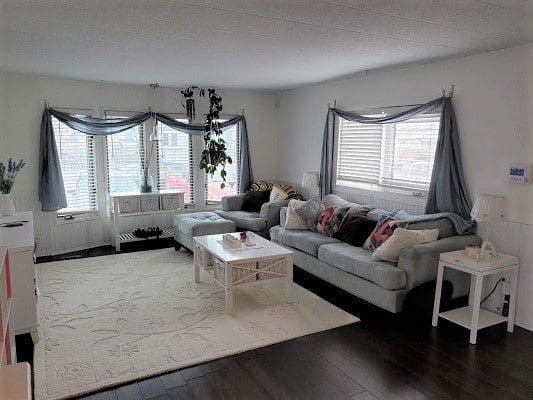 A living room with a white couch and white curtains.