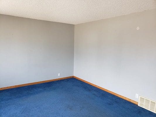 Empty room with blue carpet and white walls.