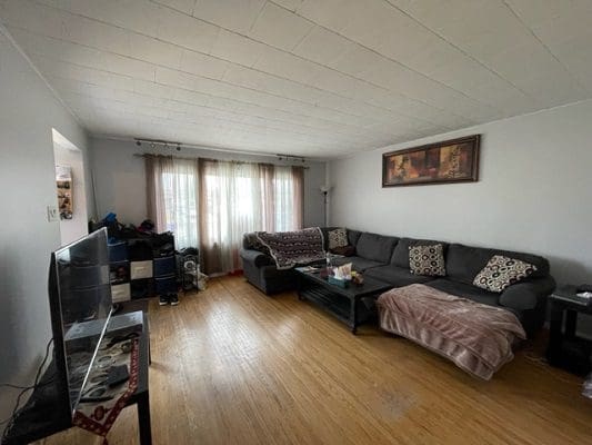 A living room with hardwood floors and a couch.