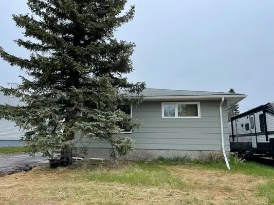 A house with a trailer parked in front of it.