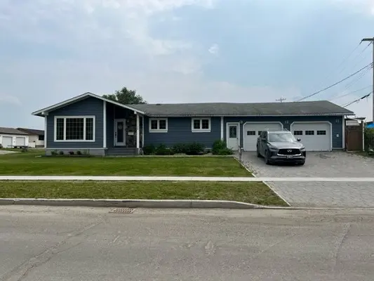 A blue house with a car parked in front of it.