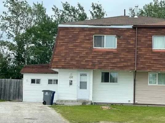 A two story house with a garage in front of it.