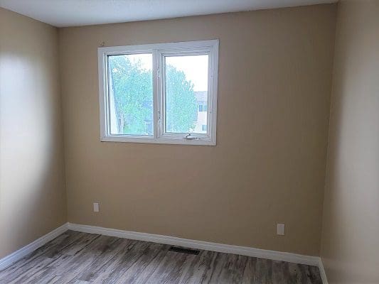 A room with hardwood floors and a window.