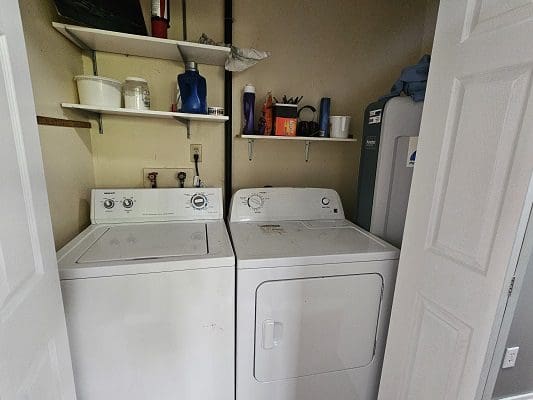 Two washers and dryers in a small room.