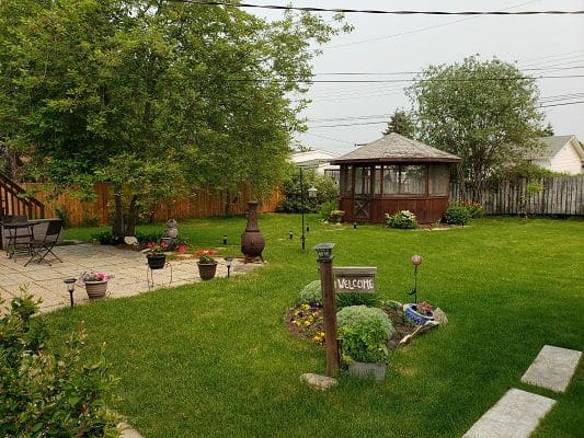 A backyard with grass and a gazebo.