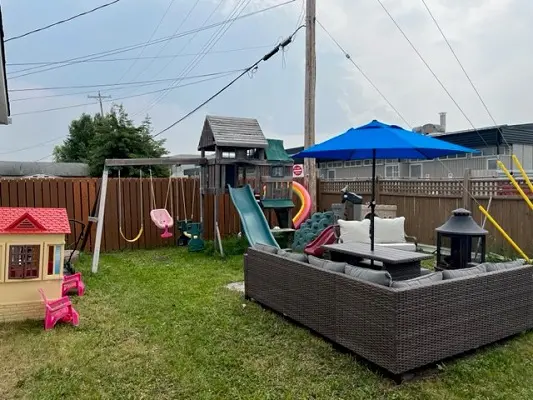 A backyard with a swing set and a slide.