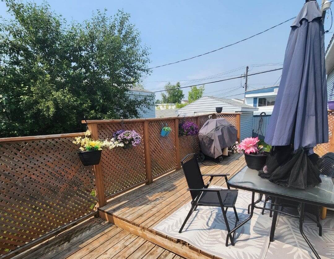 A deck with a table, chairs and umbrella.