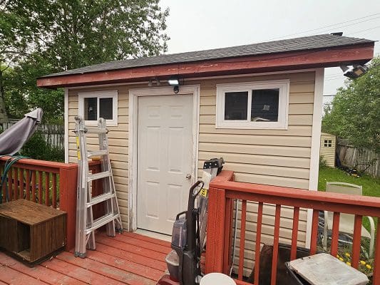 A small shed with a ladder on the deck.