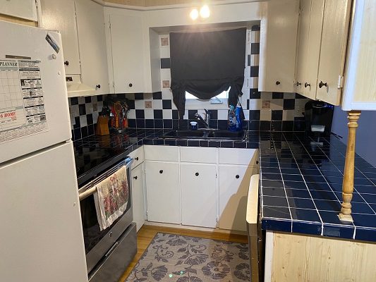 A kitchen with a black and white tiled floor.