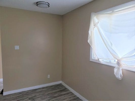A room with a window and a curtain.