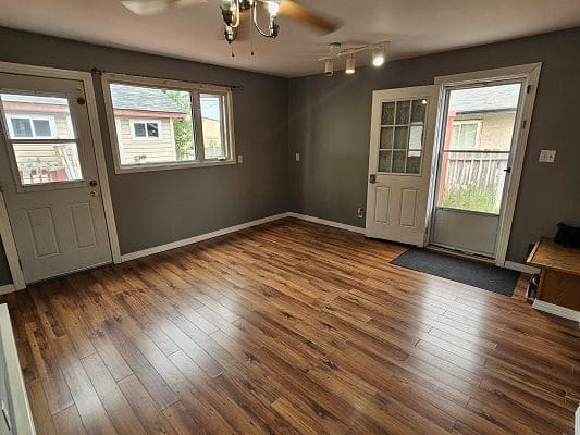 A living room with hardwood floors and a ceiling fan.