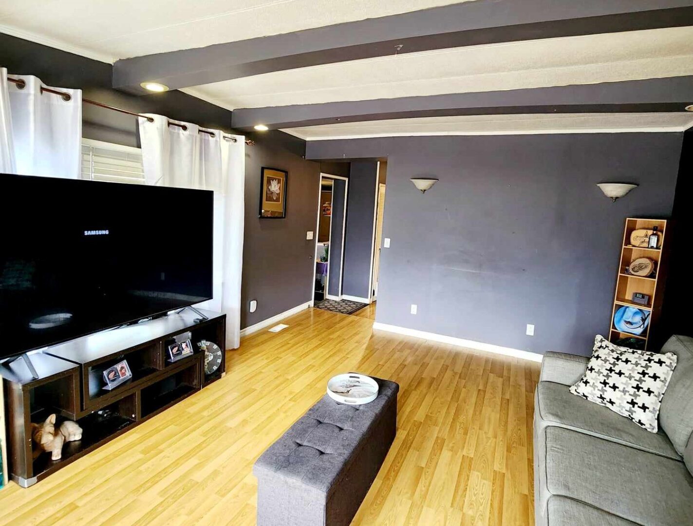 A living room with gray walls and hardwood floors.