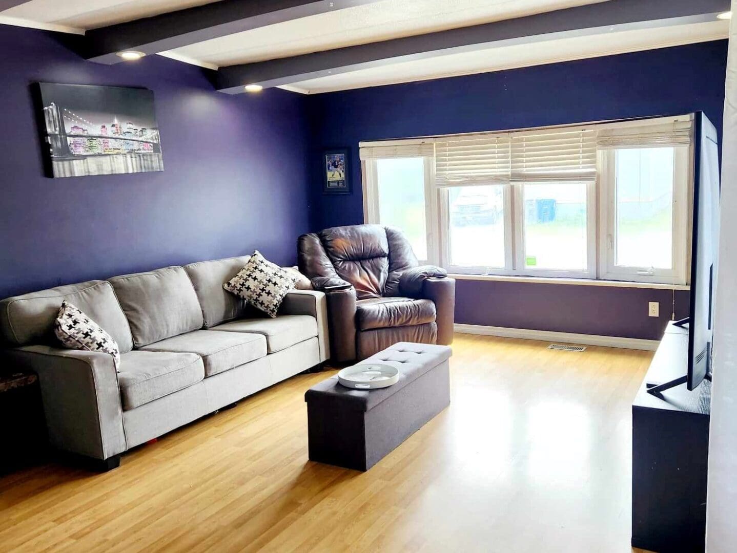 A living room with purple walls and a couch.