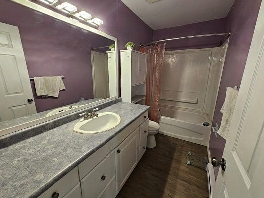A bathroom with purple walls and a white sink.