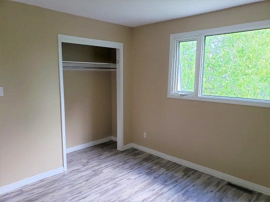 A room with hardwood floors and a closet.