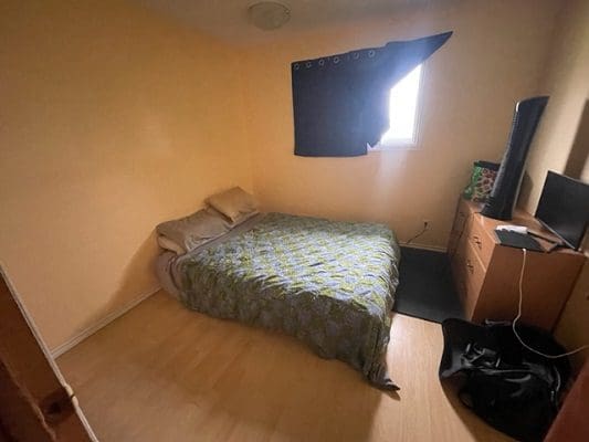 Bedroom with bed, dresser, and window.