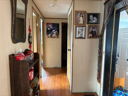 Hallway with family photos and small shelf.