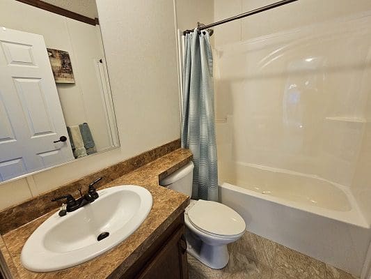 Bathroom with shower, sink, and toilet.