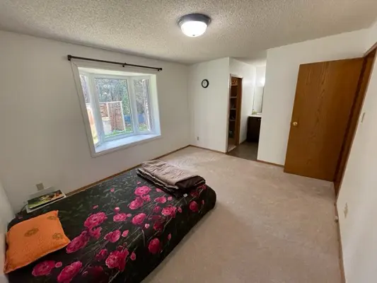 A bedroom with a bed and a window.