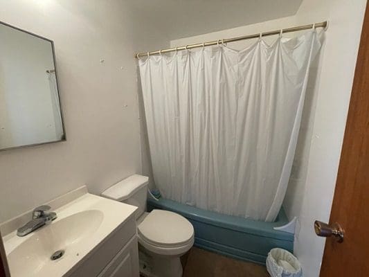Small bathroom with shower and sink.